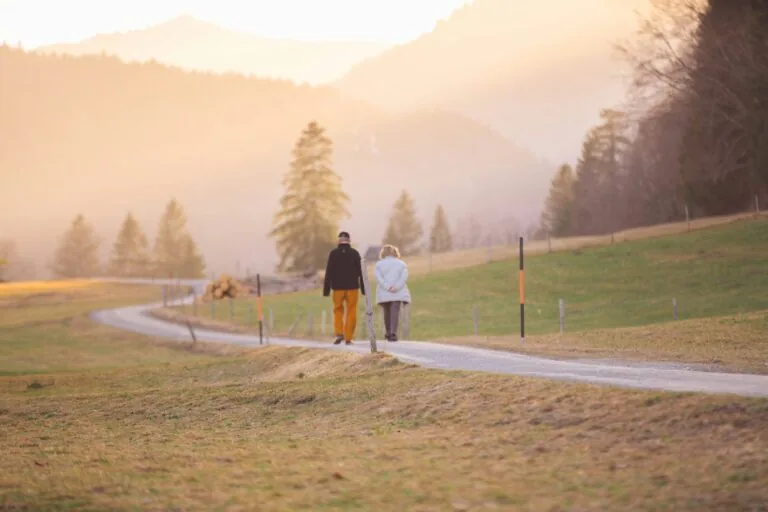 An older couple walking together through the countryside at sunset